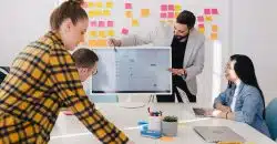 man standing behind flat screen computer monitor