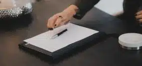 a person writing on a piece of paper