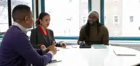 a group of people sitting around a white table